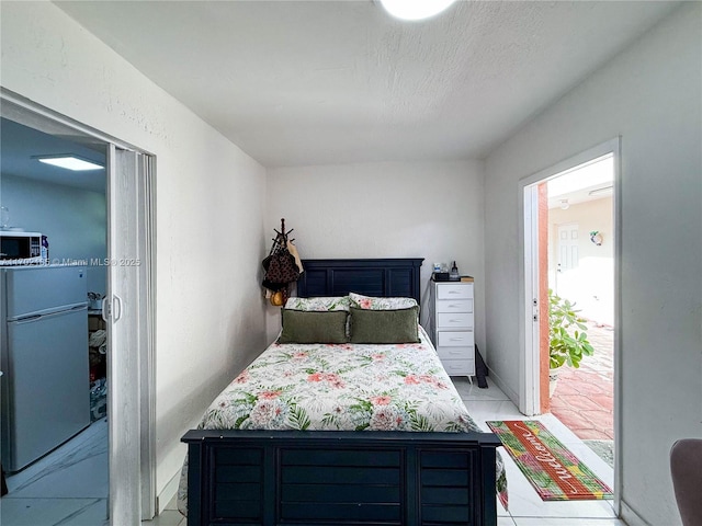 tiled bedroom featuring white fridge and a textured ceiling