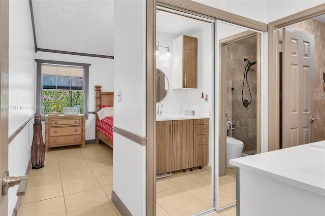 bathroom featuring vanity, toilet, tile patterned flooring, and a tile shower