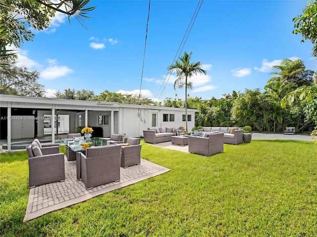 rear view of house with a yard, outdoor lounge area, and a patio