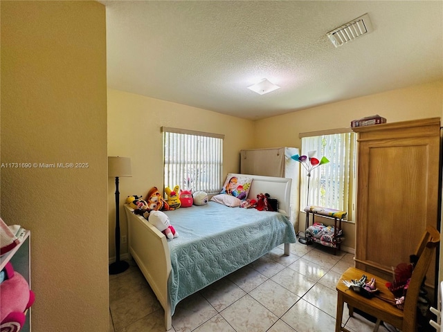 tiled bedroom featuring a textured ceiling