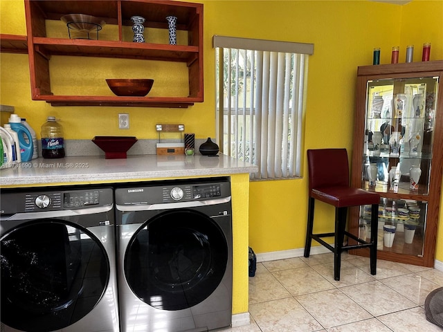 laundry area featuring separate washer and dryer and light tile patterned flooring