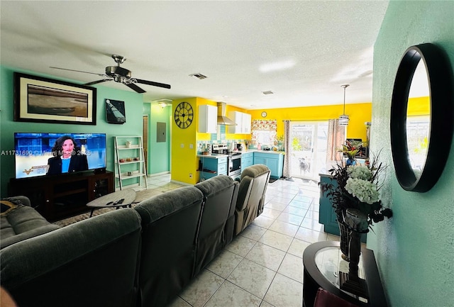 tiled living room with ceiling fan and a textured ceiling