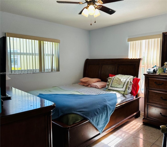 tiled bedroom featuring ceiling fan