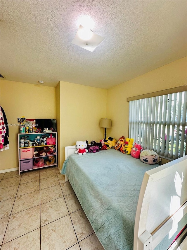 bedroom featuring tile patterned floors and a textured ceiling