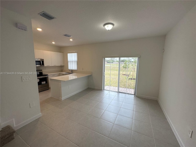 kitchen featuring light tile patterned flooring, appliances with stainless steel finishes, white cabinetry, sink, and kitchen peninsula