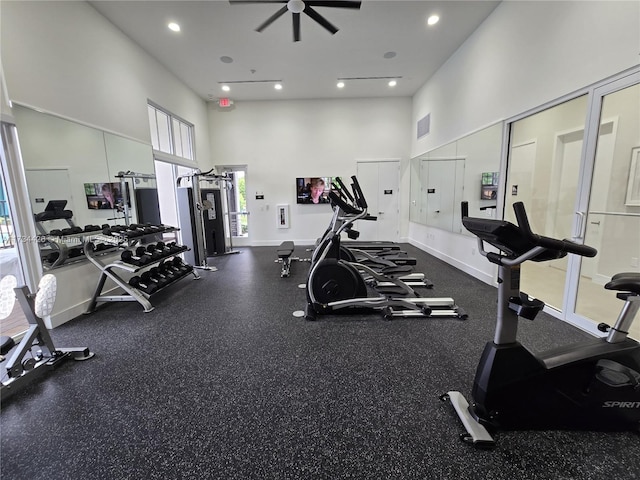 workout area with a towering ceiling and ceiling fan