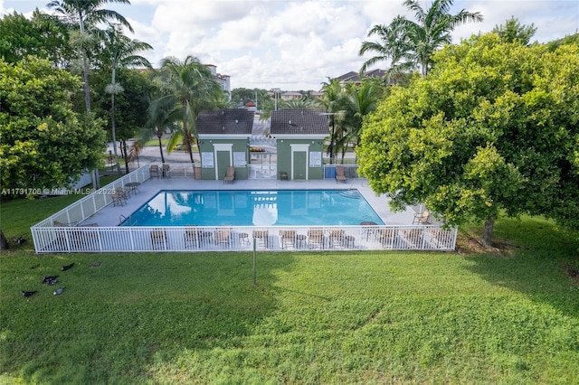 pool featuring a patio, fence, and a lawn