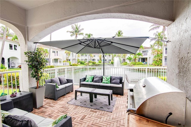 view of patio featuring an outdoor hangout area, grilling area, and a water view