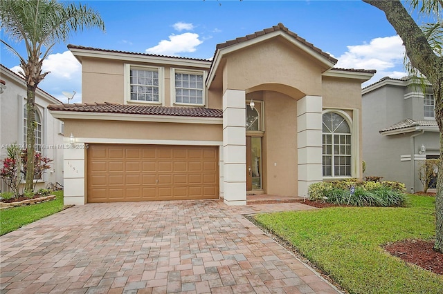 mediterranean / spanish-style home featuring a garage and a front yard