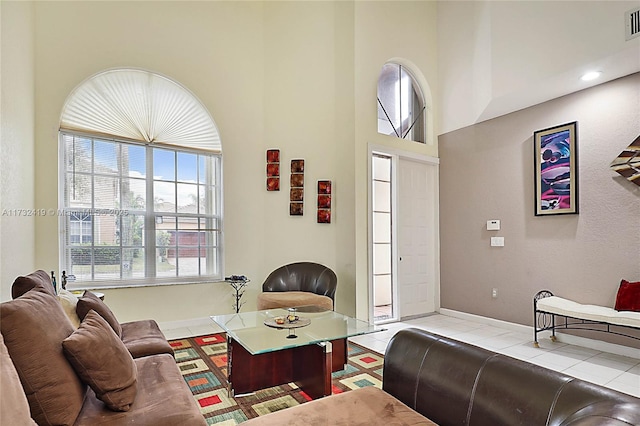 living room featuring light tile patterned floors and a high ceiling