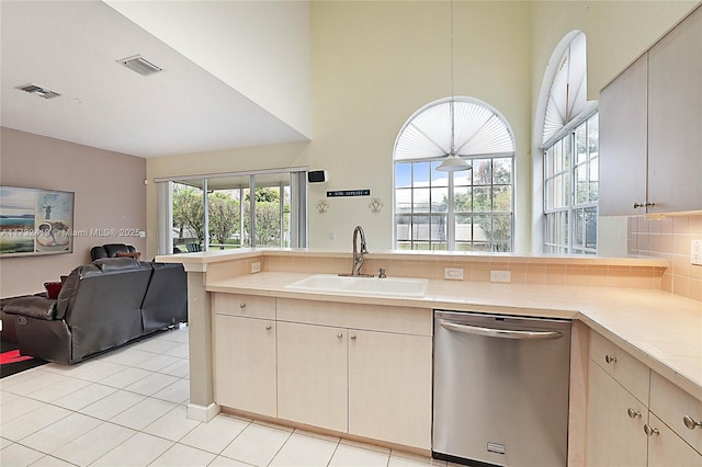 kitchen featuring dishwasher, sink, a healthy amount of sunlight, and kitchen peninsula