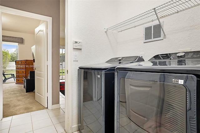 clothes washing area with washing machine and dryer and light carpet