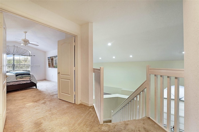 hallway with lofted ceiling and light carpet