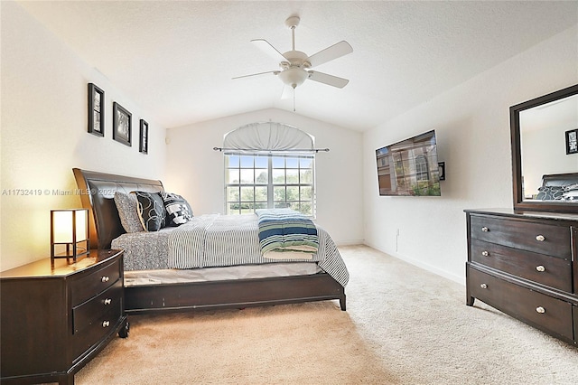 carpeted bedroom with vaulted ceiling and ceiling fan