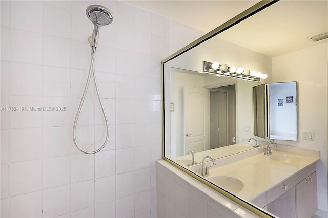 bathroom with tiled shower and vanity