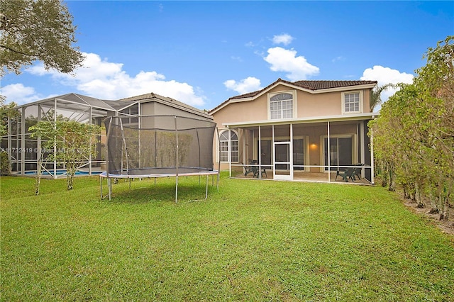 back of property with a lawn and a sunroom