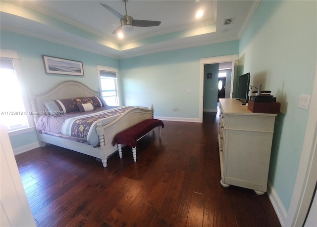 bedroom featuring crown molding, a tray ceiling, dark wood-type flooring, and ceiling fan