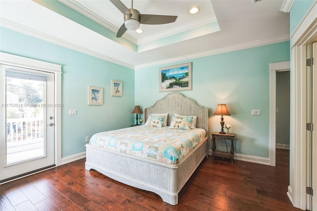 bedroom featuring baseboards, wood-type flooring, ornamental molding, access to exterior, and a tray ceiling