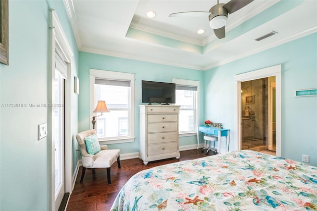 bedroom featuring baseboards, visible vents, ornamental molding, dark wood-type flooring, and a tray ceiling