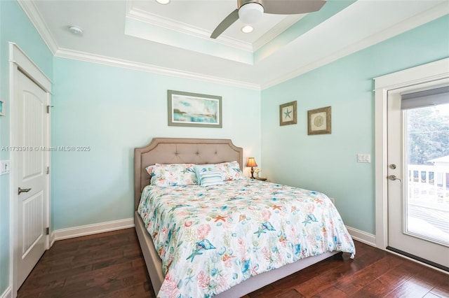 bedroom featuring access to exterior, a tray ceiling, crown molding, hardwood / wood-style floors, and baseboards