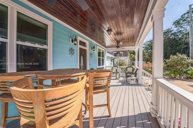 deck featuring covered porch, outdoor dining area, and a ceiling fan