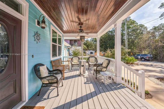 wooden terrace with covered porch and a ceiling fan