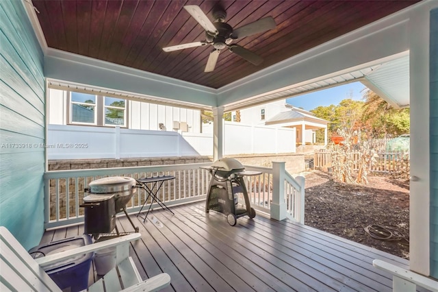 wooden terrace featuring a ceiling fan and a fenced backyard