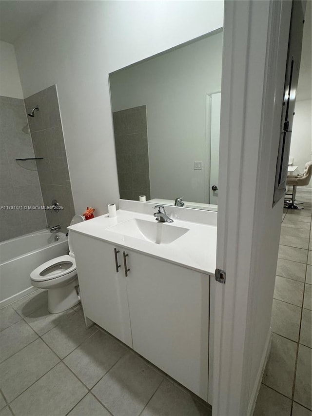 full bathroom featuring tile patterned flooring, tiled shower / bath, vanity, and toilet