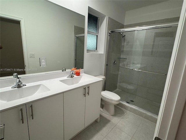 bathroom featuring vanity, tile patterned flooring, a shower with door, and toilet