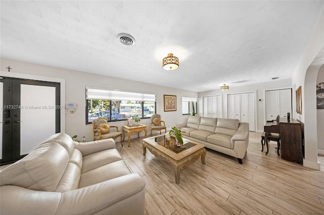 living room featuring a textured ceiling and light hardwood / wood-style floors