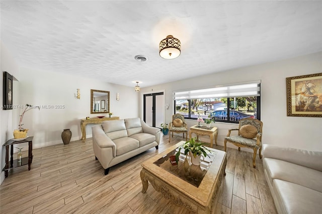 living room featuring light hardwood / wood-style floors and a textured ceiling