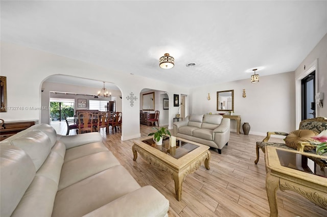 living room with a notable chandelier and light wood-type flooring