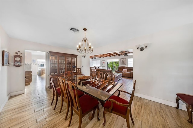 dining space featuring light hardwood / wood-style floors and a notable chandelier