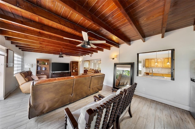 living room with sink, ceiling fan, light hardwood / wood-style floors, wooden ceiling, and beamed ceiling