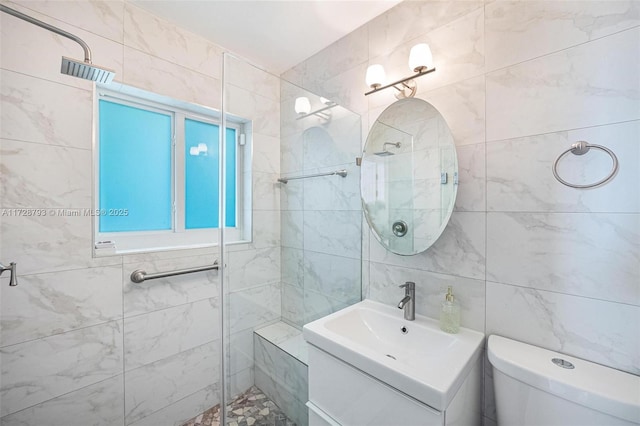 bathroom with tile walls, vanity, toilet, and a tile shower