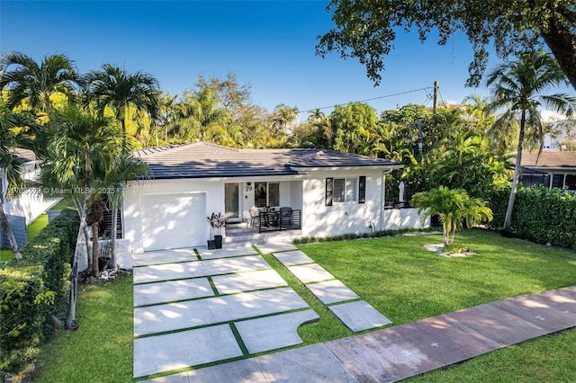 single story home featuring a garage and a front lawn