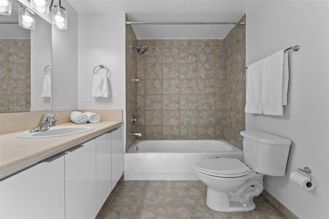 full bathroom featuring vanity, tiled shower / bath, tile patterned floors, and toilet