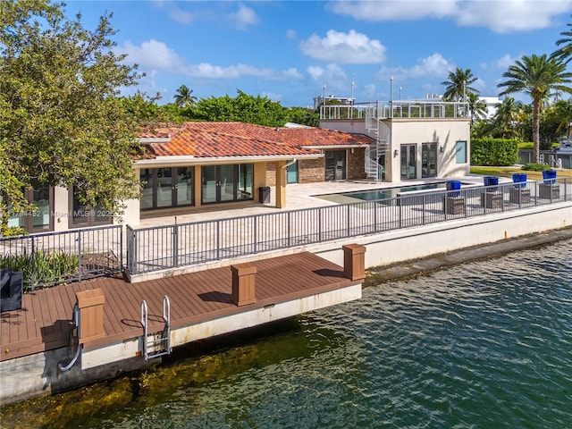 dock area featuring a patio area, fence, a fenced in pool, and a water view