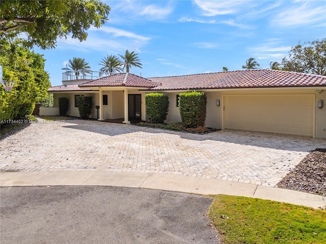 view of front of house with a garage, a tiled roof, and stucco siding