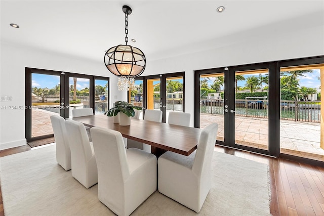 dining area with french doors, light wood-style flooring, and a healthy amount of sunlight