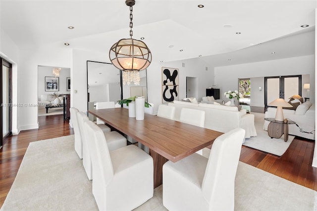 dining space featuring recessed lighting, a notable chandelier, vaulted ceiling, and hardwood / wood-style floors