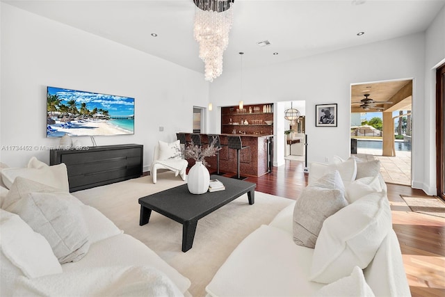 living room featuring a chandelier, wood finished floors, visible vents, and recessed lighting