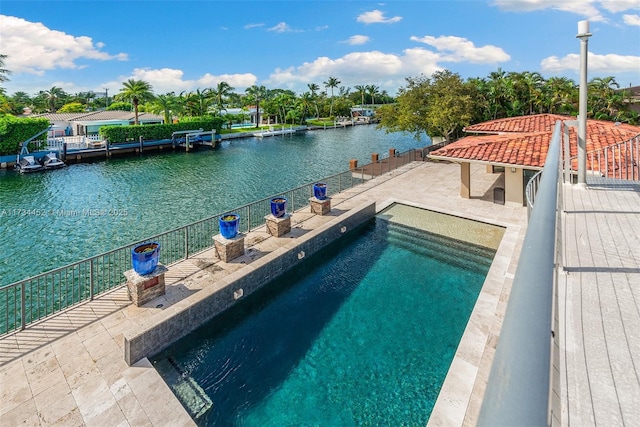 view of swimming pool featuring a patio area, a water view, fence, and a fenced in pool