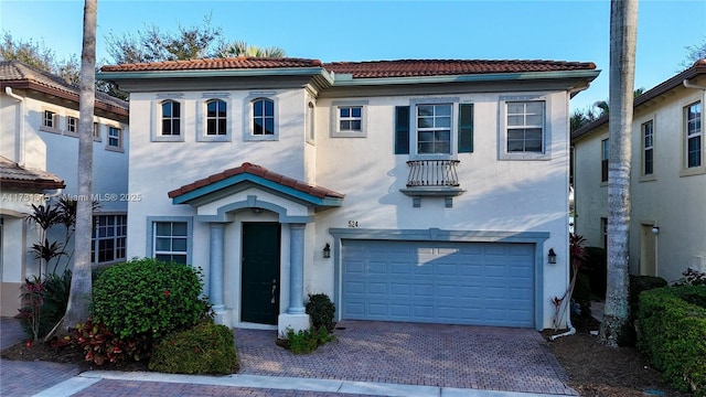 mediterranean / spanish-style house featuring stucco siding, decorative driveway, and a tiled roof