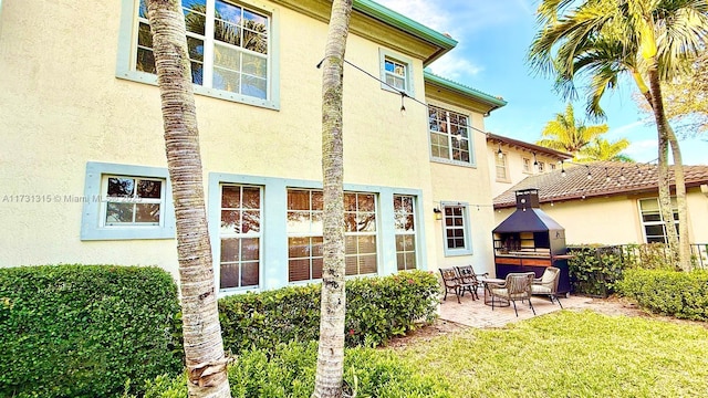 back of property with fence, a patio, and stucco siding