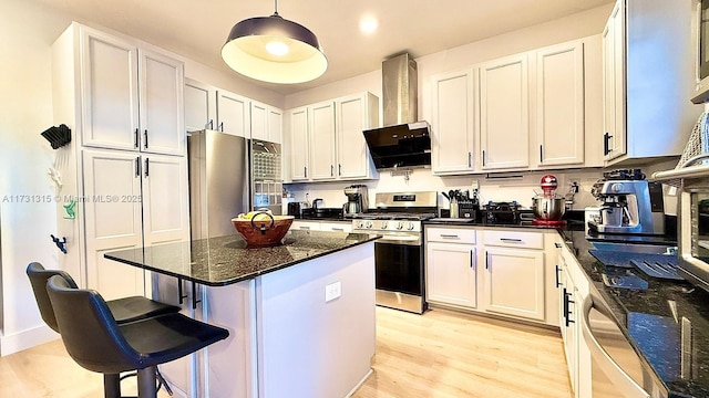 kitchen featuring white cabinets, light wood-style flooring, a breakfast bar area, and stainless steel appliances