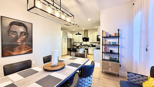 dining space featuring light wood-style flooring, baseboards, and recessed lighting