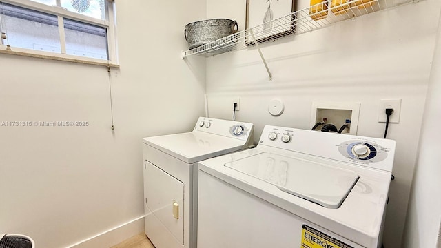 washroom featuring laundry area, washing machine and dryer, and baseboards