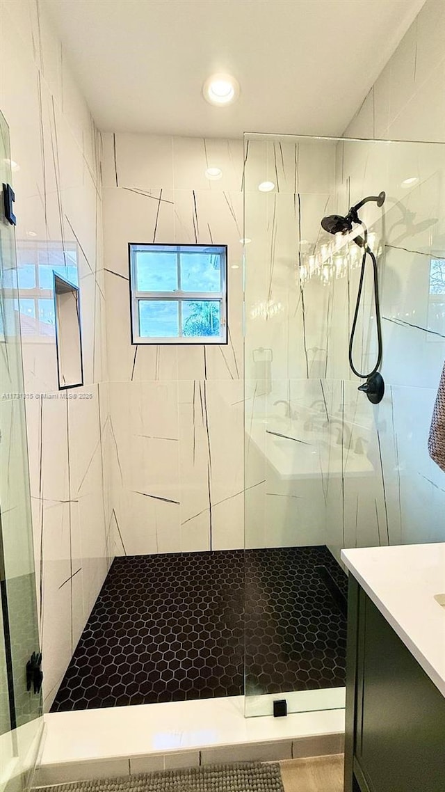 bathroom featuring a tile shower and vanity