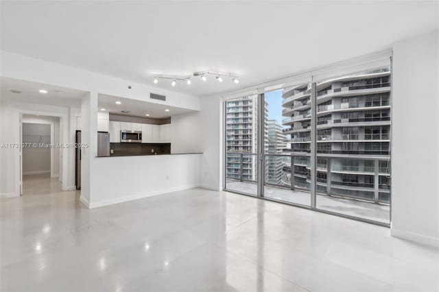 unfurnished living room with baseboards, visible vents, and recessed lighting